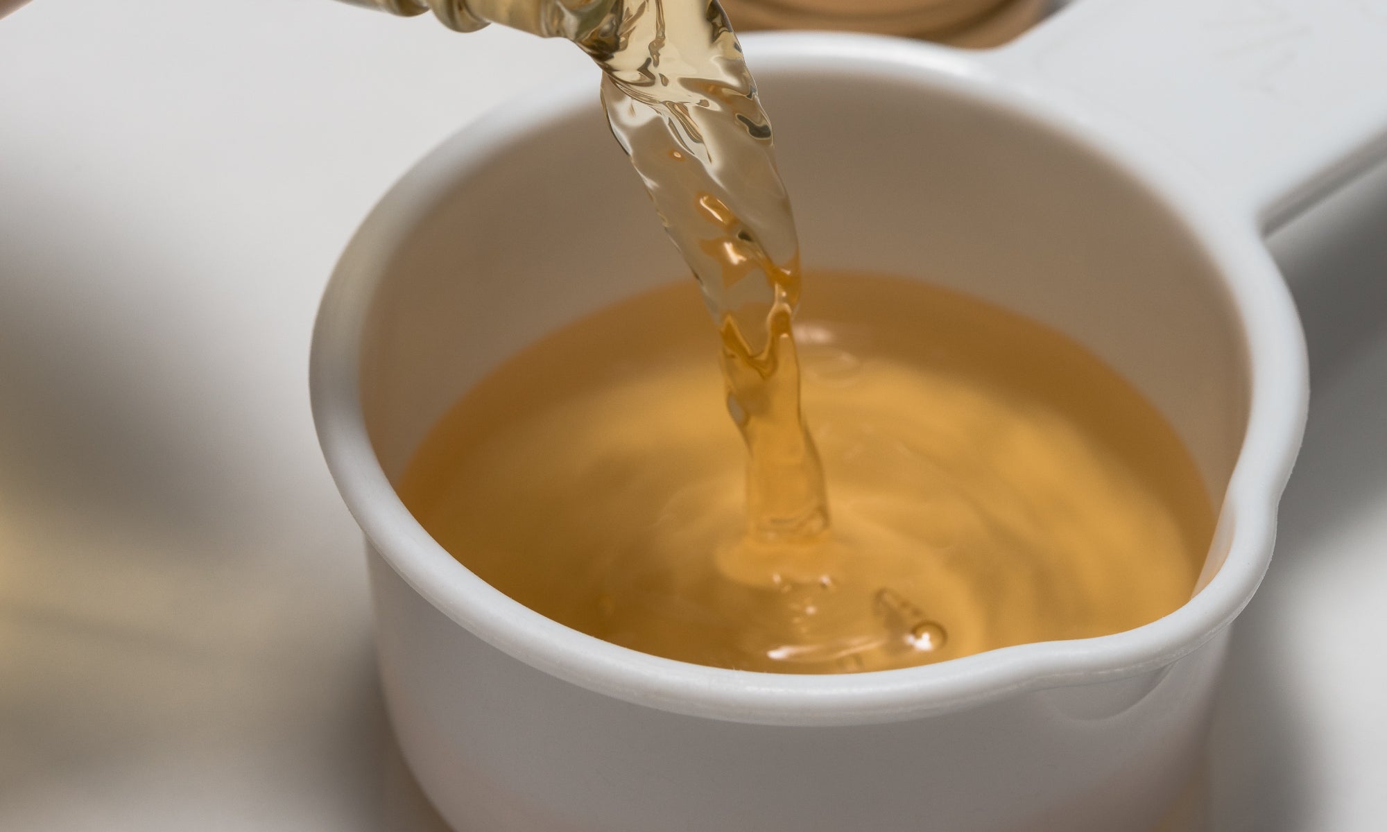 Apple Cider Vinegar pouring into a small bowl