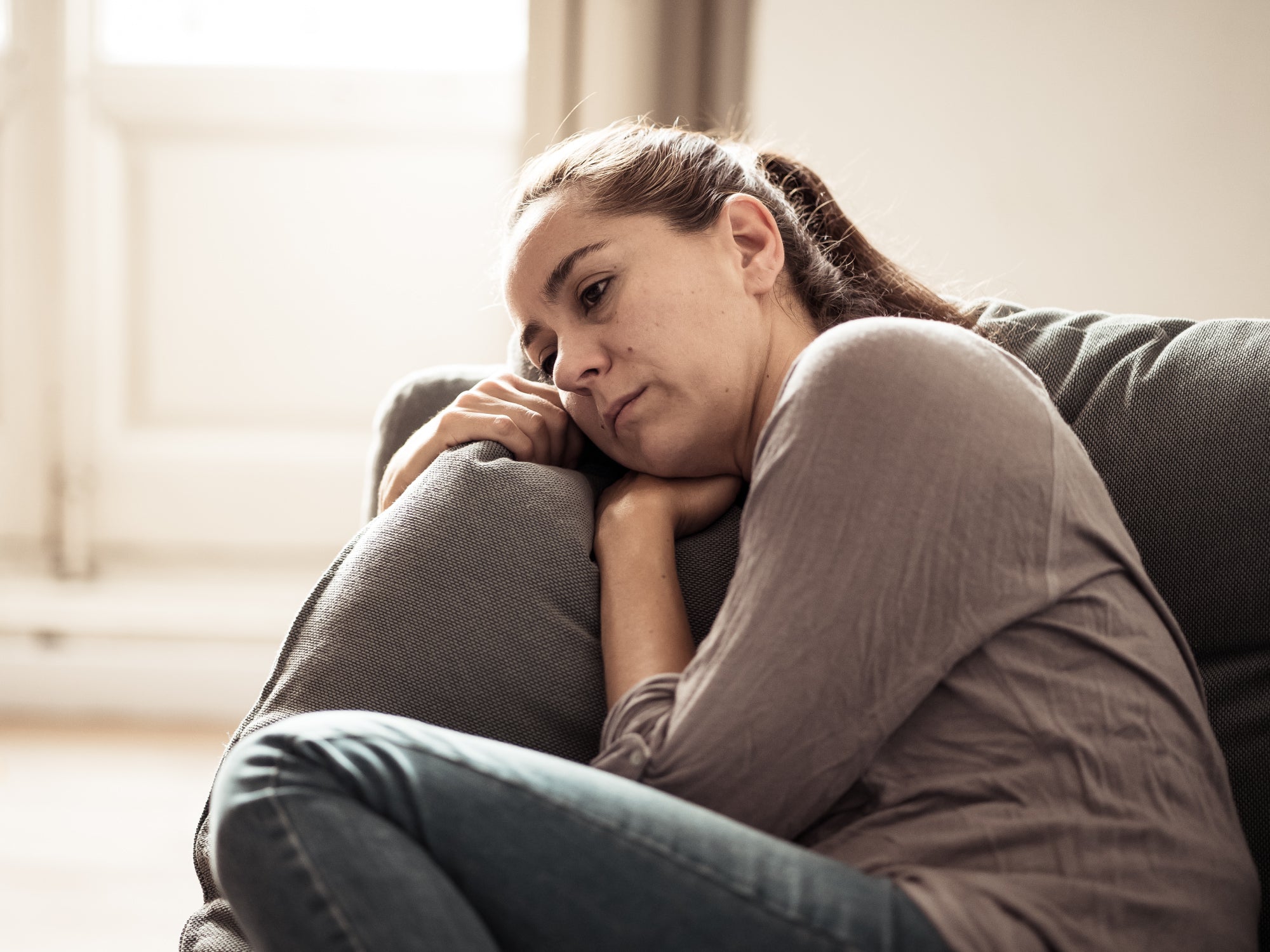 Person sitting on a sofa feeling unwell